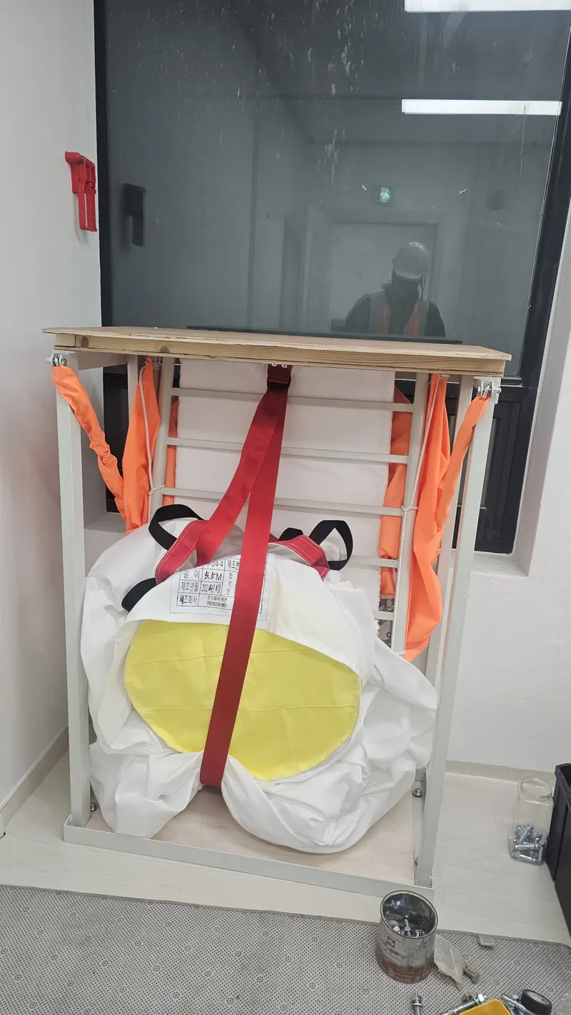 고층건물 비상탈출 장비 안내 — 실내 창가에 거치된 수직구조대 설치 상태