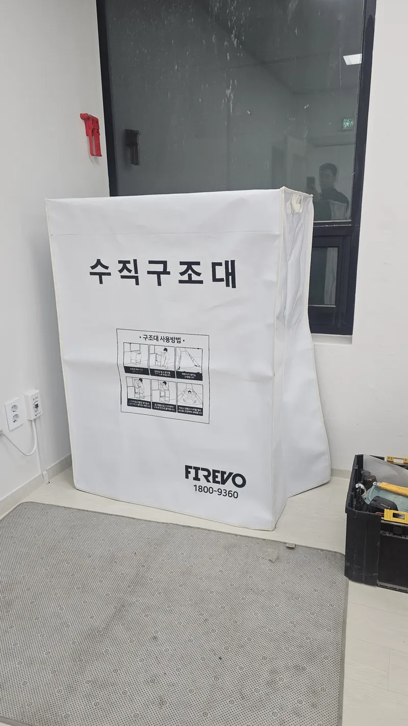 고층건물 비상탈출 장비 안내 — 포대 케이스에 수납된 수직구조대 보관 상태